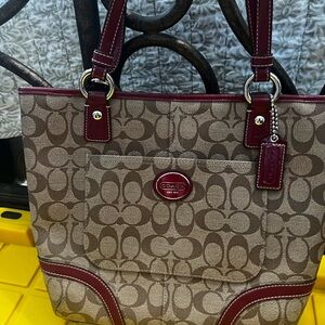 Coach brown tote w/ signature “C’s” w/ burgundy trim excellent used condition.
